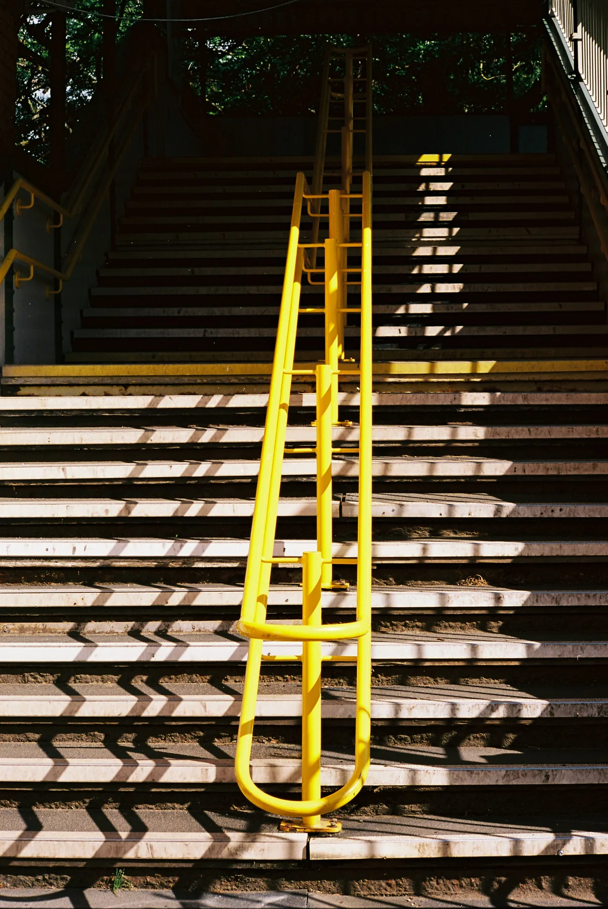 Un escalier graphique traversé par une rambarde jaune, symbole de direction et de progression